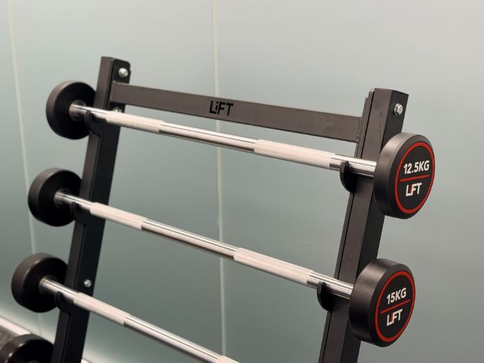 Rack of fixed-weight barbells
