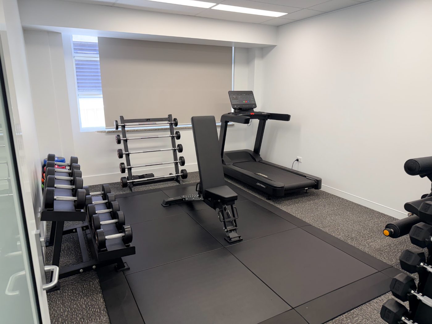 The clinic gym with treadmill, adjustable bench, dumbbell racks and leg extension machine